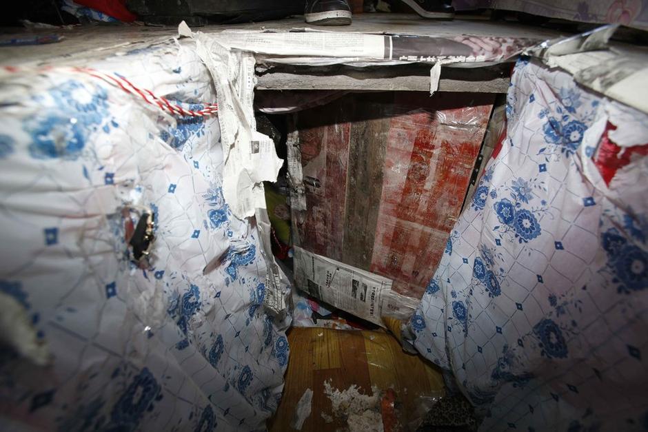 陳小龍在出租屋外，自行又圍起一堵圍墻，安裝了一個門。圍墻上都是豎起的鐵釘，外面堆著土，鄰居猜是從地底挖出來的。洞口就在床邊，0.5米見方，深約1.5米。洞口表面一塊紙板掩蓋，打開紙板跳入洞底，是一扇小木門，木門外有插銷，可以從外面鎖上。