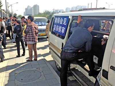 昨日，朝陽區(qū)看守所門前有人排隊。大門外還停有多輛寫有“律師會見”字樣的車。