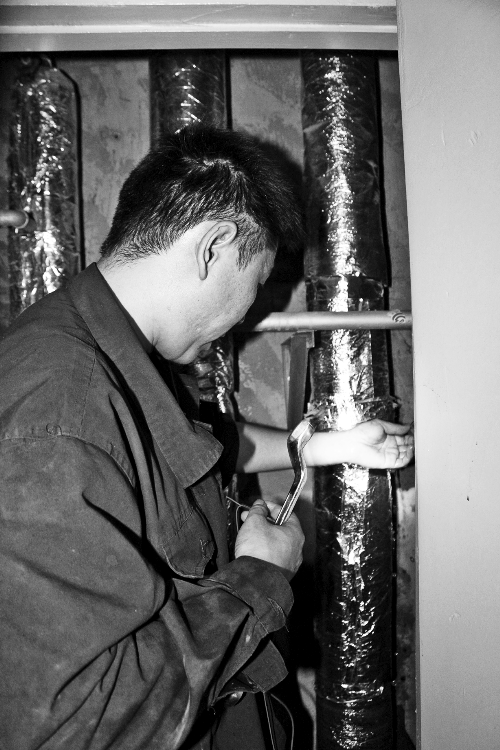 苗師傅一邊進(jìn)行維修，一邊用耳機(jī)接聽市民的電話。