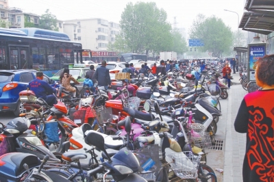 省人民醫(yī)院北門，路邊的公交站牌處停滿非機動車，上、下客只能在快車道上。