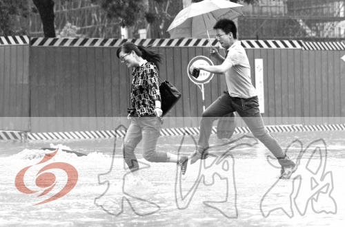 鄭州經(jīng)三路與北環(huán)交叉口處，積水較深，行人們不得不“練輕功”。 記者 白周峰 攝影