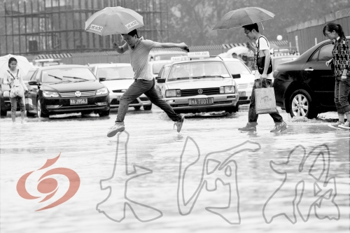 鄭州經(jīng)三路與北環(huán)交叉口處，積水較深，行人們不得不“練輕功”。 記者 白周峰 攝影