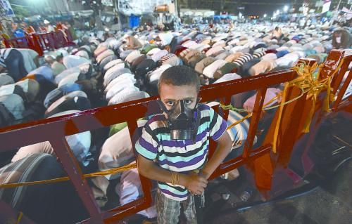 當(dāng)?shù)貢r(shí)間28日晚，在埃及開(kāi)羅納賽爾城，一名小男孩頭戴防毒面具參加穆兄會(huì)的集會(huì)示威。