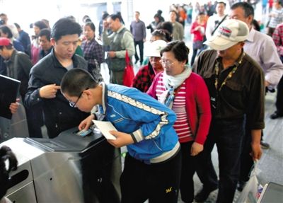 去年5月5日，14號線園博園站，乘客刷卡出地鐵。北京公交地鐵將實行計程票制，多乘坐多付費。