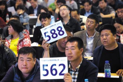 昨日，拍賣現(xiàn)場競拍者舉牌競拍。新京報(bào)記者