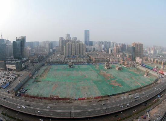 2016年4月，經(jīng)過持續(xù)攻堅，親賢社區(qū)西北片區(qū)的拆遷工作基本告一段落，但在鋪設(shè)了防塵綠網(wǎng)的空地中，至今仍有3戶居民選擇了“堅守”。(拍攝：2016年4月4日)