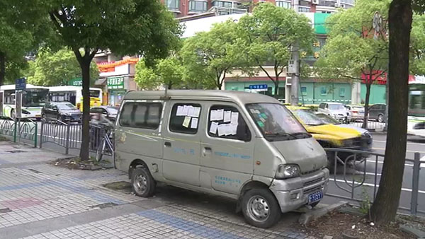 被棄置在人行道上的面包車(chē)。