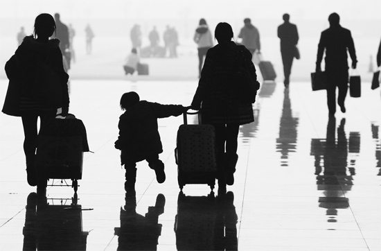 昨日，鄭州東站，一名孩子拉著媽媽和包裹快樂地奔走在春運(yùn)的途中