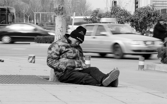 2月2日，鄭州市中州大道農(nóng)業(yè)路立交橋下，50歲的王文德打算在臨近春節(jié)前再接些零活兒，由于疲憊，他睡著