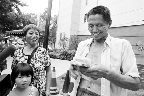 昨日，鄭州市明達(dá)路與豐慶路交叉口西300米路南，來自中牟的瓜農(nóng)拿到西瓜款，笑開顏東方今報(bào)記者袁曉強(qiáng)