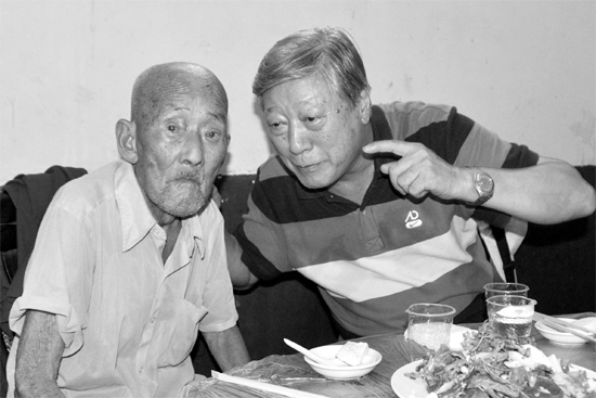 昨日，來自北京的英雄后代胡冠軍（右）專門趕到西平縣看望抗戰(zhàn)老兵孫殿修老人