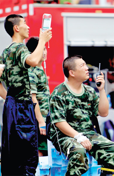 火場外，被消防戰(zhàn)士稱為“李大隊(duì)”的救援人員掛著吊瓶現(xiàn)場指揮