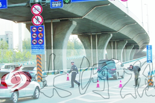 交警在東風路從北向南上橋口處擺上反光錐，間歇放行