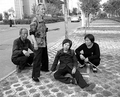 2013年4月28日，平頂山市市政府附近，受害者郭小蕊（化名）的家屬鳴冤，郭小蕊的母親杜玉花癱坐在地上。