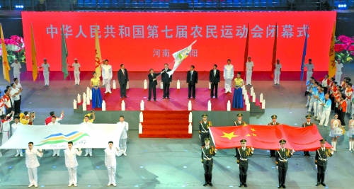 南陽市市長穆為民將農(nóng)運會會旗遞交到下一屆東道主吉林省松原市市長李相國手里。