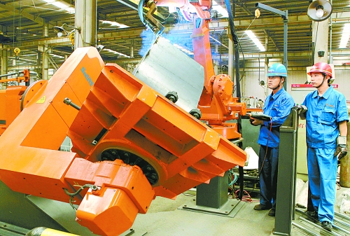 圖為龍工集團中原公司的職工正在操作機器人焊接裝載機。