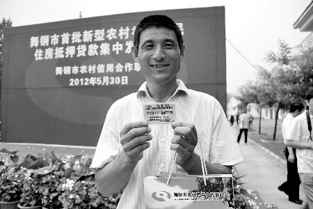 領(lǐng)到貸款，農(nóng)民開心地笑了。