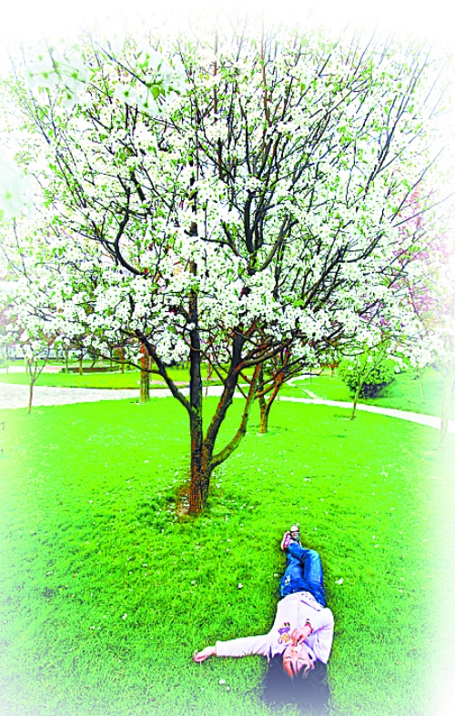 　孩子愜意地躺在社區(qū)內(nèi)的草坪上。