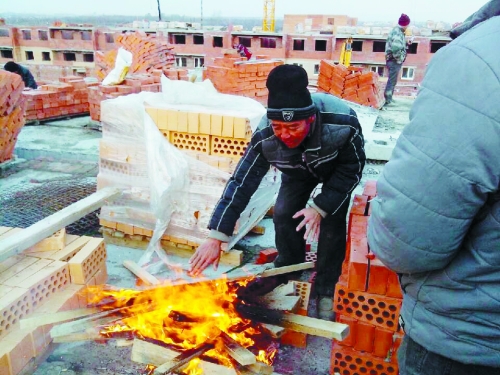 在俄羅斯工地打工時(shí)，因?yàn)樘焯?，工人不得不在工地生火取暖。（圖由方先生提供）