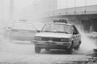 施工的道路上，車輛通過塵土飛揚。