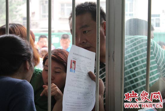 不少家長(zhǎng)擠在報(bào)名窗口前咨詢報(bào)名事宜。