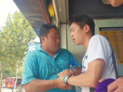 記者正查看照片，突遭藍(lán)衣男強搶手機。