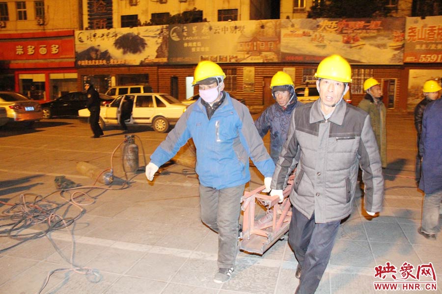 23點(diǎn)56分，第一塊兒廣告牌已經(jīng)分割完畢，地面上的20多名工人將拆除下來的鋼件撞車運(yùn)走。