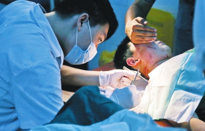 孩子身上有7道傷痕，其中兩道需要縫合，其他的均為擦傷，醫(yī)生正對(duì)他施治。