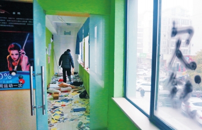 　健身會所地上一片狼藉，玻璃上噴著黑色“欠錢”二字。