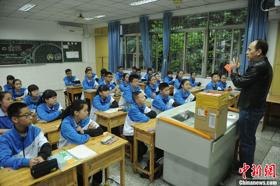 圖為老師正在向同學(xué)們講解用非智能手機(jī)對他們的好處。