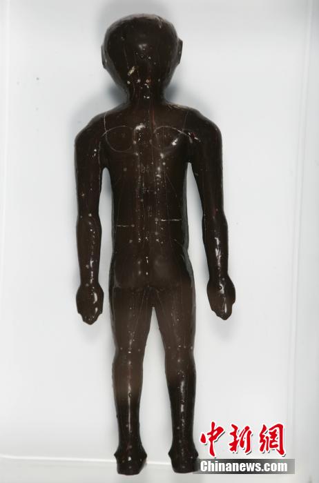 圖為出土的人體經(jīng)穴漆俑。