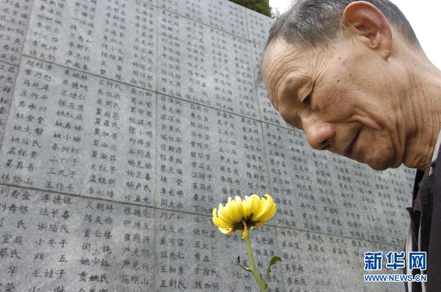 2006年4月5日，74歲的南京大屠殺幸存者佘子清手捧鮮花，祭奠被日軍殺害的母親。