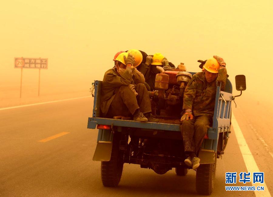4月23日，一輛拉載公路施工人員的三輪車在沙塵暴中行駛在酒泉市瓜州縣城郊的公路上。