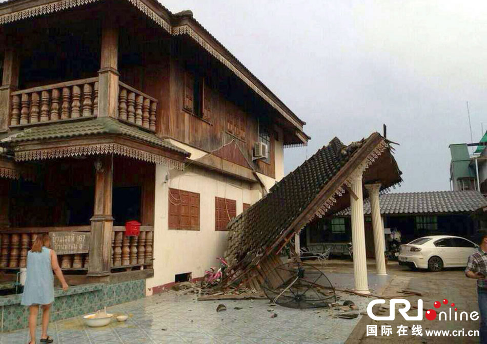 當(dāng)?shù)貢r(shí)間2014年5月5日，泰國(guó)清萊，一名婦女看著受損的房屋。 圖片來(lái)源：東方IC