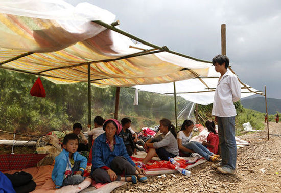 暴雨馬上來(lái)臨，村民們?cè)诤?jiǎn)易帳篷下躲雨。澎湃新聞 程藝輝 圖