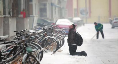 小伙子跪在樓前，一直抬頭看著樓上。 孫立國/攝