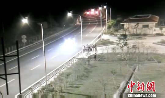 看到車輛經(jīng)過，孩子們便急忙跑到一旁的花圃上?！【焦﹫D　攝