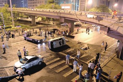 路虎沖下國(guó)貿(mào)橋砸中一輛起亞轎車，橋上厚達(dá)幾十厘米的水泥護(hù)欄被撞斷，碎石四處散落，數(shù)十群眾在現(xiàn)場(chǎng)圍觀。