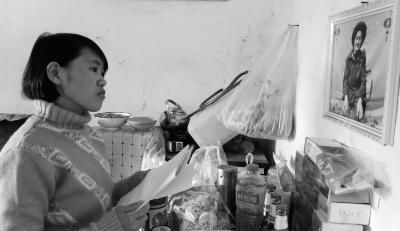 錢仁鳳站在母親遺像前。未能見母親最后一面是她的一大遺憾。