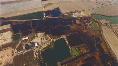 4月19日，廊坊市大城縣南趙扶鎮(zhèn)，津保路以北約八九百米處，一個(gè)巨大的污水坑中，水體呈現(xiàn)紅褐色。 新京報(bào)記者 尹亞飛 攝