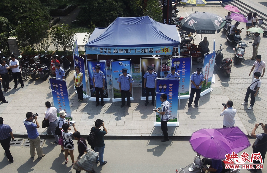 執(zhí)法人員用宣傳牌圍擋占道經(jīng)營攤位。