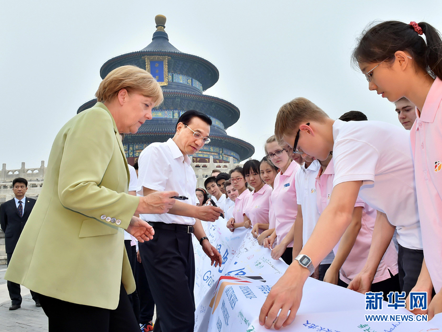 李克強同默克爾在紀念橫幅上簽名。