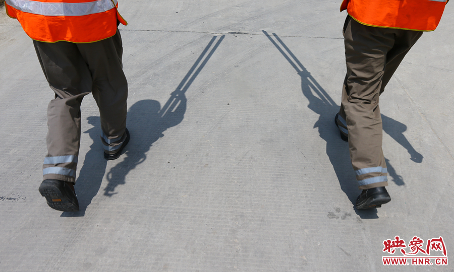 中午時分，烈日當頭，在滾燙的水泥地面上投下了小小的身影