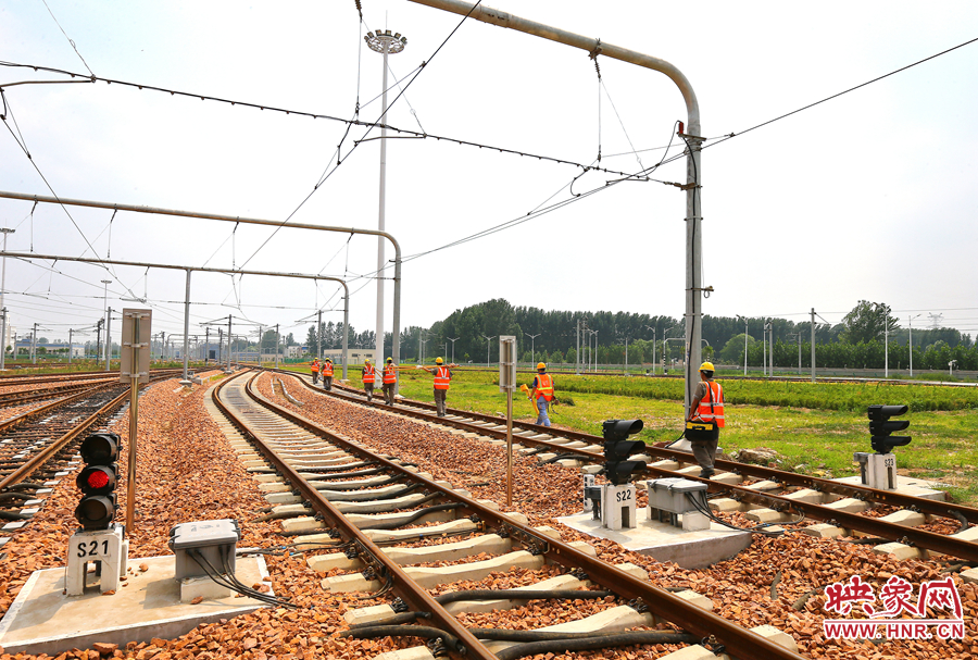 在太陽的直射下，檢修工人扛著沉重的設備向施工地點出發(fā)