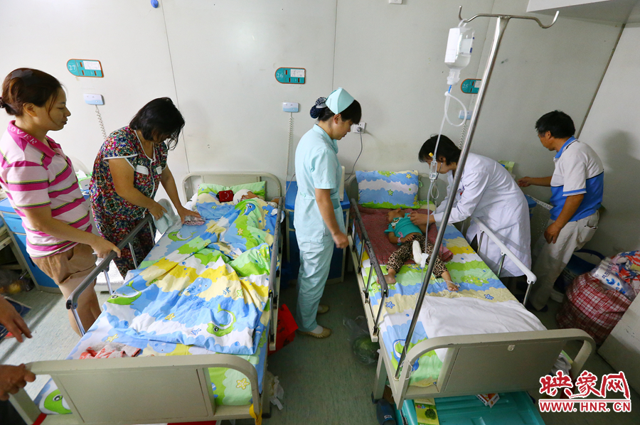 手術(shù)前，畫面右側(cè)的大龍正在接受醫(yī)生的檢查，左側(cè)的小龍還在熟睡。