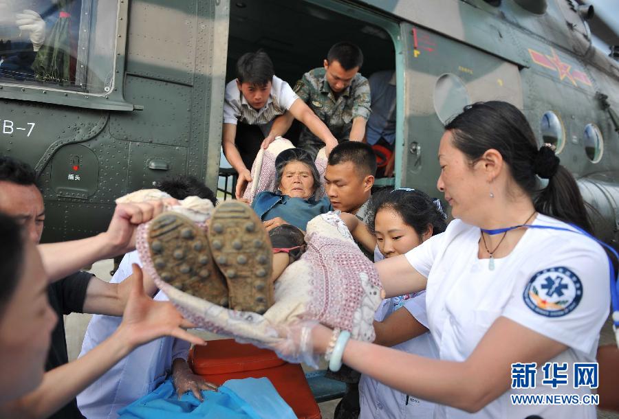 8月5日，醫(yī)護(hù)人員將一名通過直升機(jī)從震中轉(zhuǎn)運(yùn)出來的傷員運(yùn)下飛機(jī)。