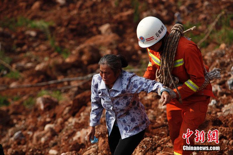 一位消防戰(zhàn)士將一位失去親人的老人扶離滑坡點(diǎn)。