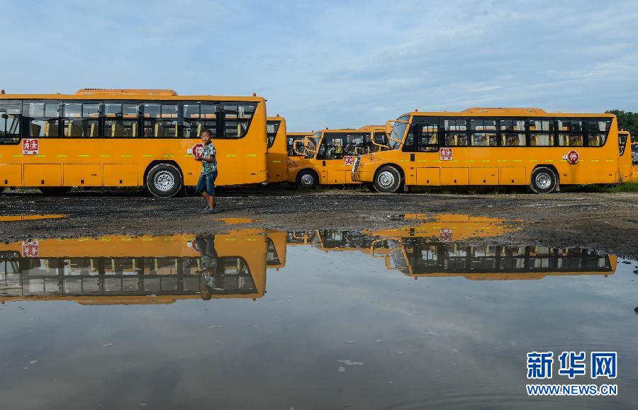 8月29日，溫嶺市城西街道芷勝莊村一名小男孩從閑置的校車邊走過(guò)。