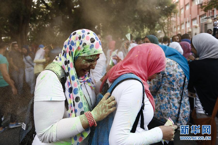 10月16日，在埃及首都開(kāi)羅，兩名女青年在“彩色跑”活動(dòng)中躲避人們拋撒的彩色粉末。