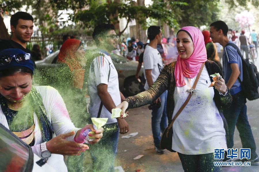 10月16日，在埃及首都開(kāi)羅，一名女青年在“彩色跑”活動(dòng)中拋撒彩色粉末。